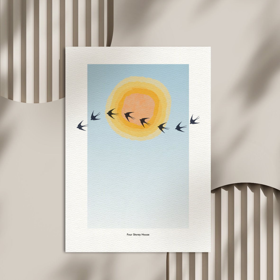 Original A2 Art Print - Swallows featuring a minimalist design of swallows flying across a soft blue sky with layered yellow and orange sun, framed in a white border.