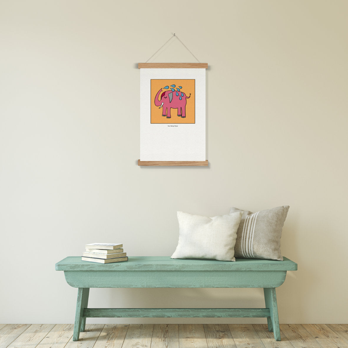Original A2 Art Print - Pink Elephant hung on a beige wall above a rustic teal bench with cushions and stacked books, showcasing unique framed art prints in a minimalist setting.