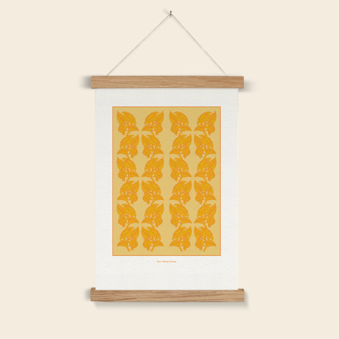 Wall art with orange leaf pattern on a beige background, hanging on a white wall.