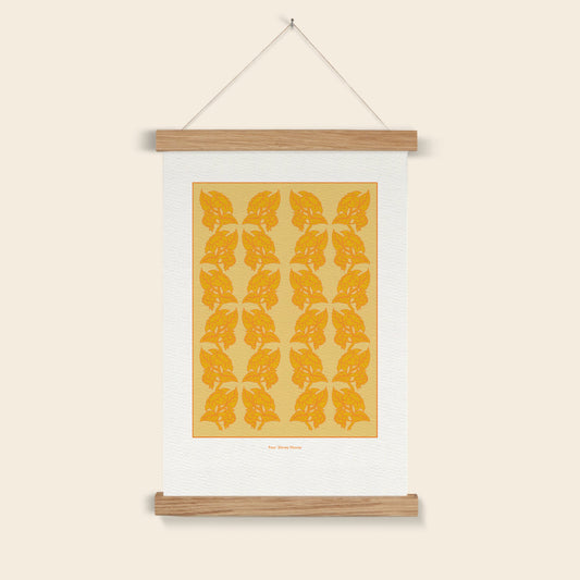 Wall art with orange leaf pattern on a beige background, hanging on a white wall.